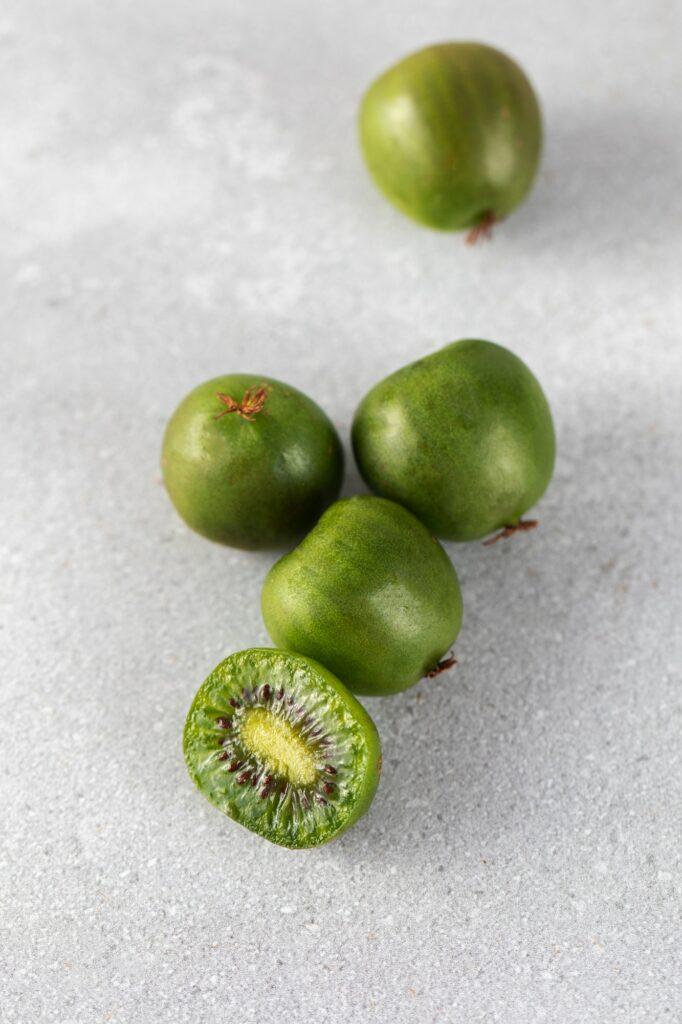 mini kiwi on a gray table whole and half tropical fruits kiwi berry