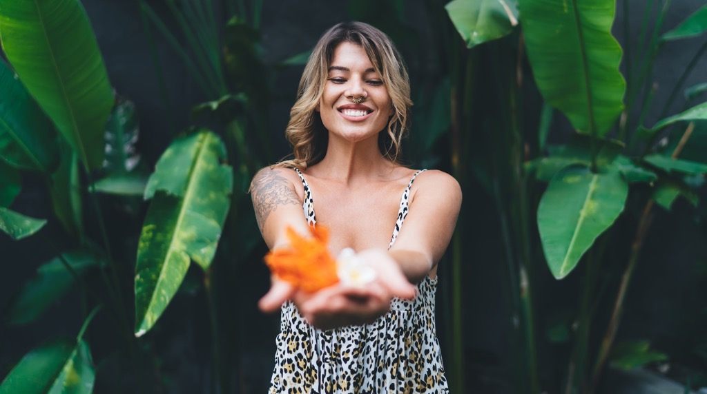 young woman with tropical flowers in green garden 1