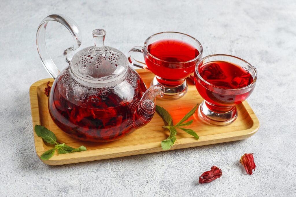 hot hibiscus tea in a glass mug and glass teapot