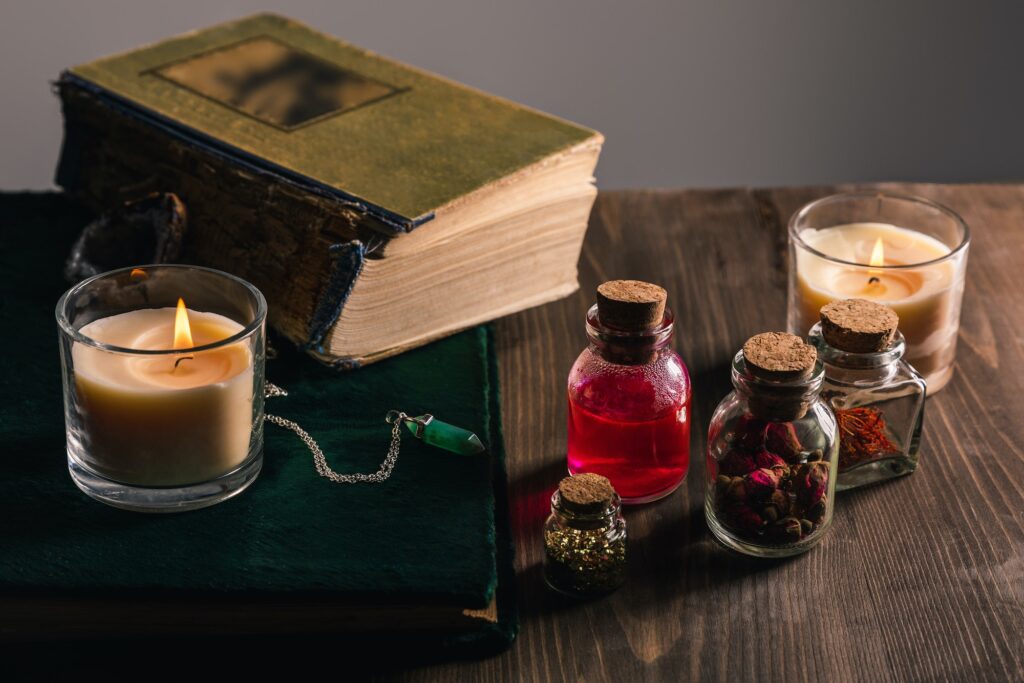 jars with herbs and tincture books candles on wooden and grey background