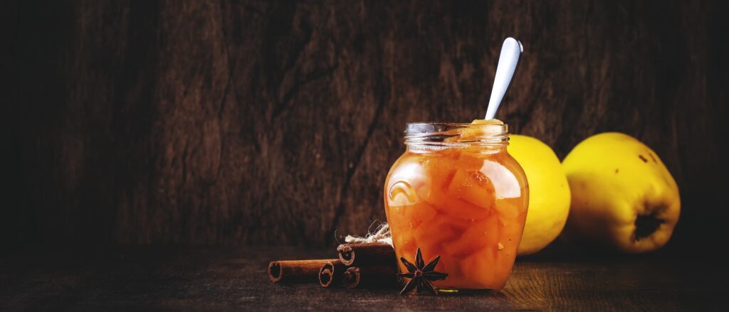 winter quince jam or confiture in glass jar with cinnamon and anise